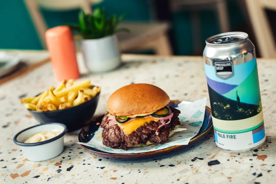 Double cheeseburger and fries with a can of pale ale